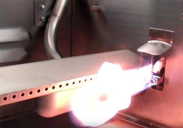 Built-in gas grill burner igniting with visible blue flame