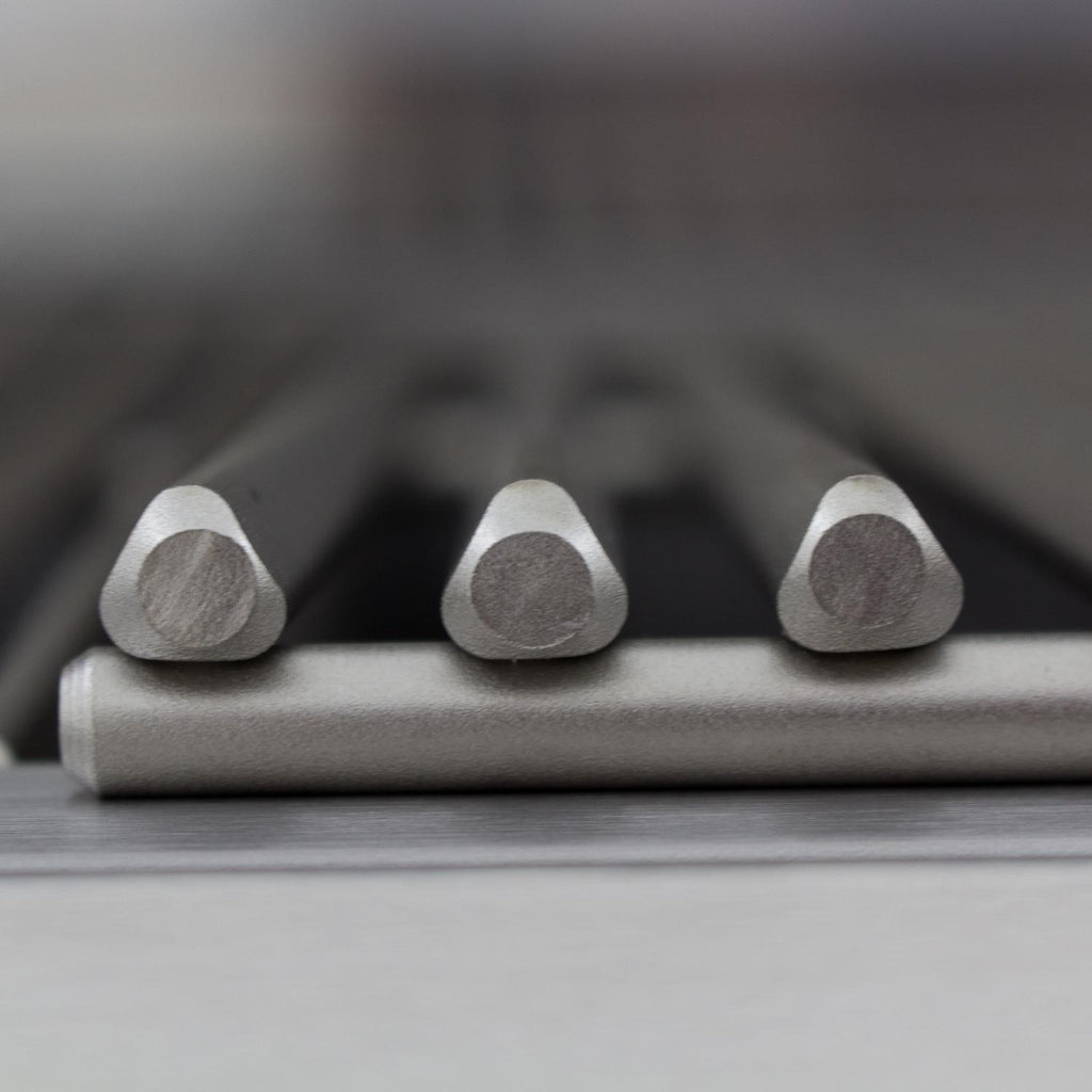 Gas grill burner ports under a heat shield with three metal burner heads
