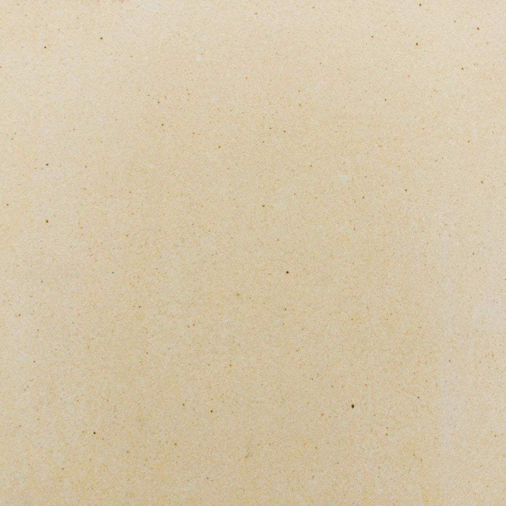Beige ceramic pizza stone surface, speckled texture.