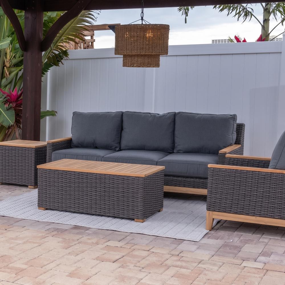 Outdoor 4-piece furniture set with dark gray cushions, charcoal woven sofa, and wood-top tables