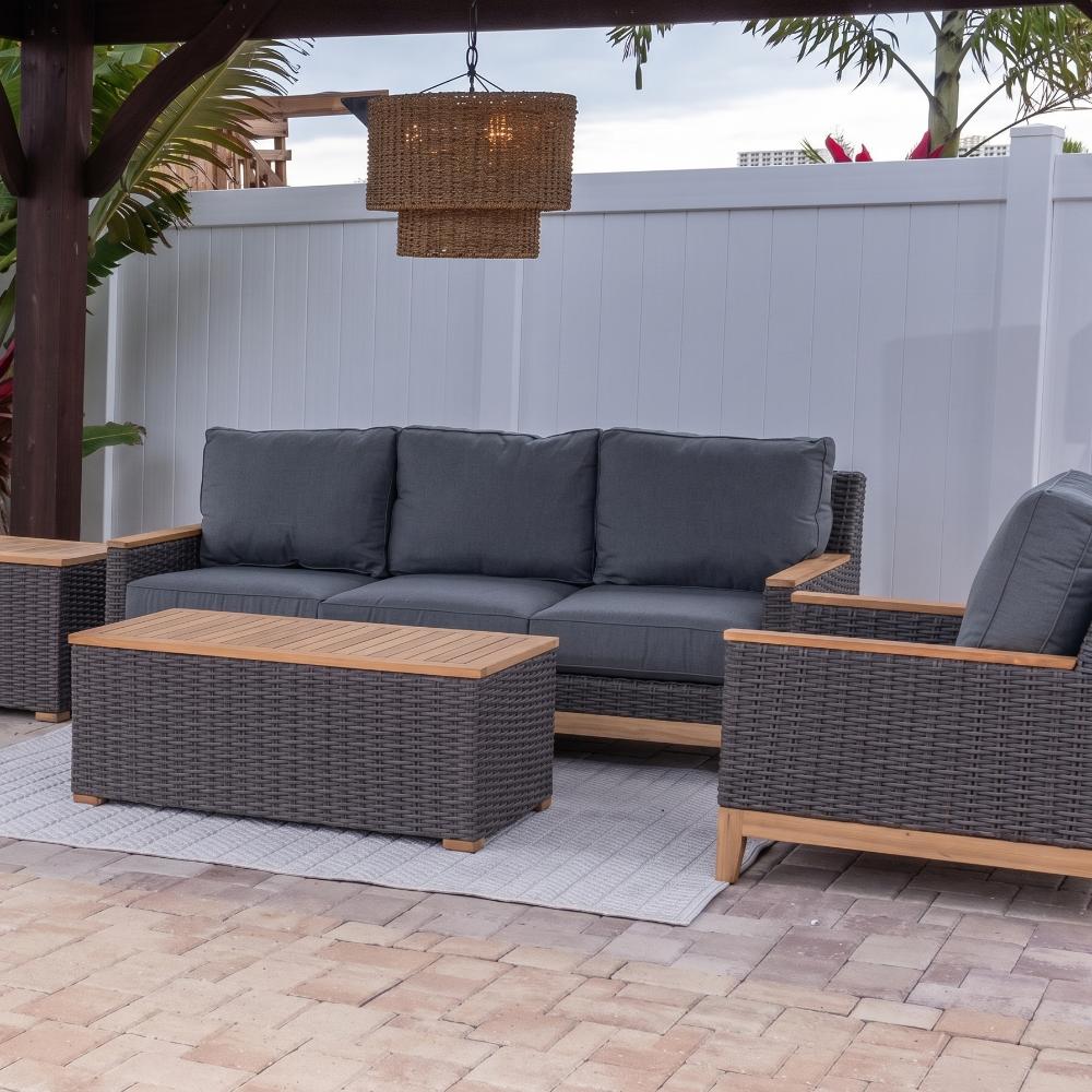 Outdoor gray wicker sofa with dark gray cushions and two matching corner ottomans