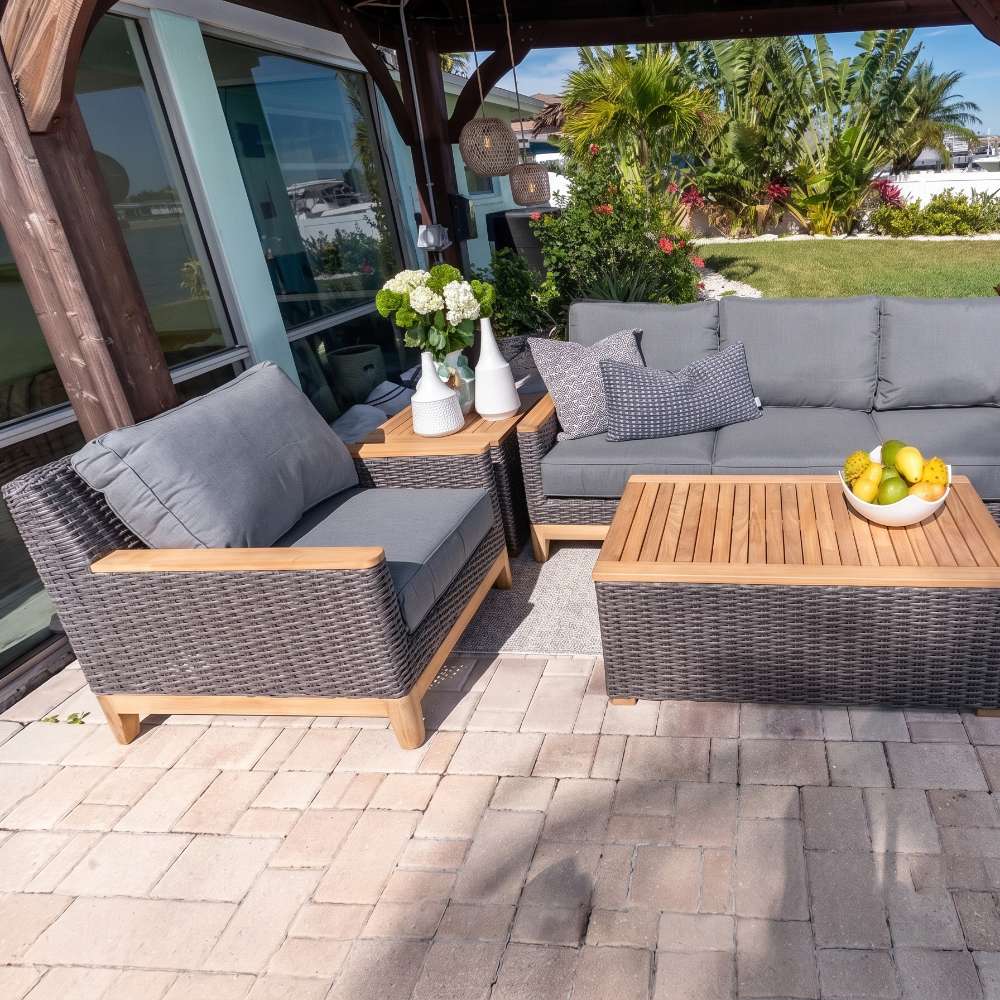 Outdoor patio lounge chairs with dark woven frames and light gray cushions