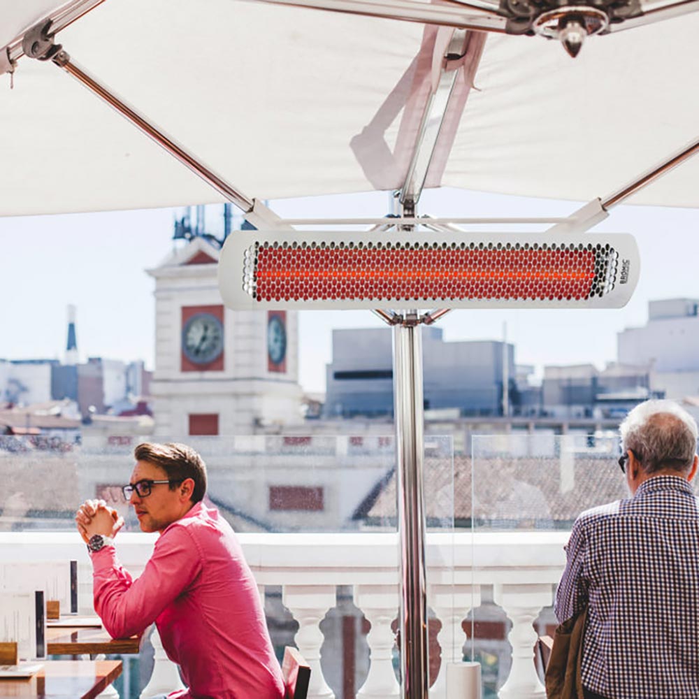 Electric heater bar with red heating element in a patio umbrella structure