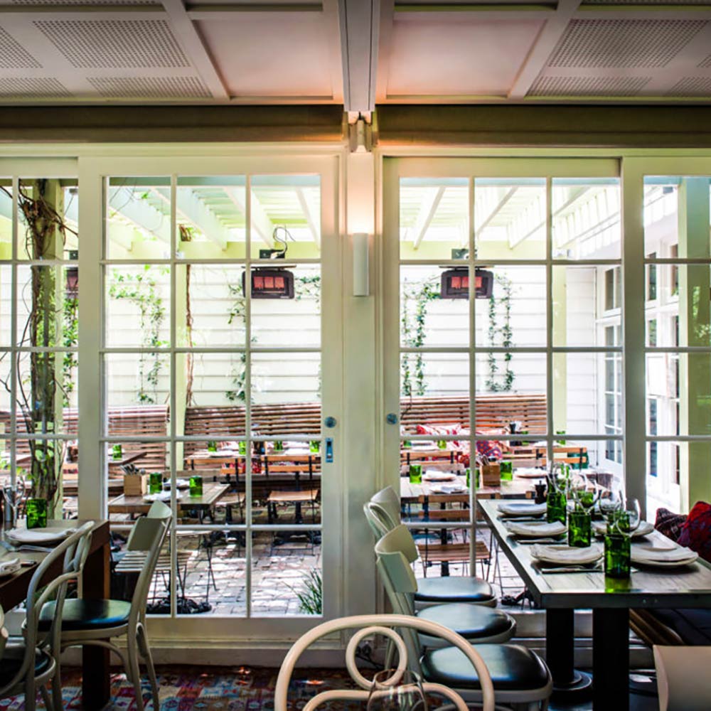 Covered patio radiant heaters mounted on ceiling with glowing burner panels