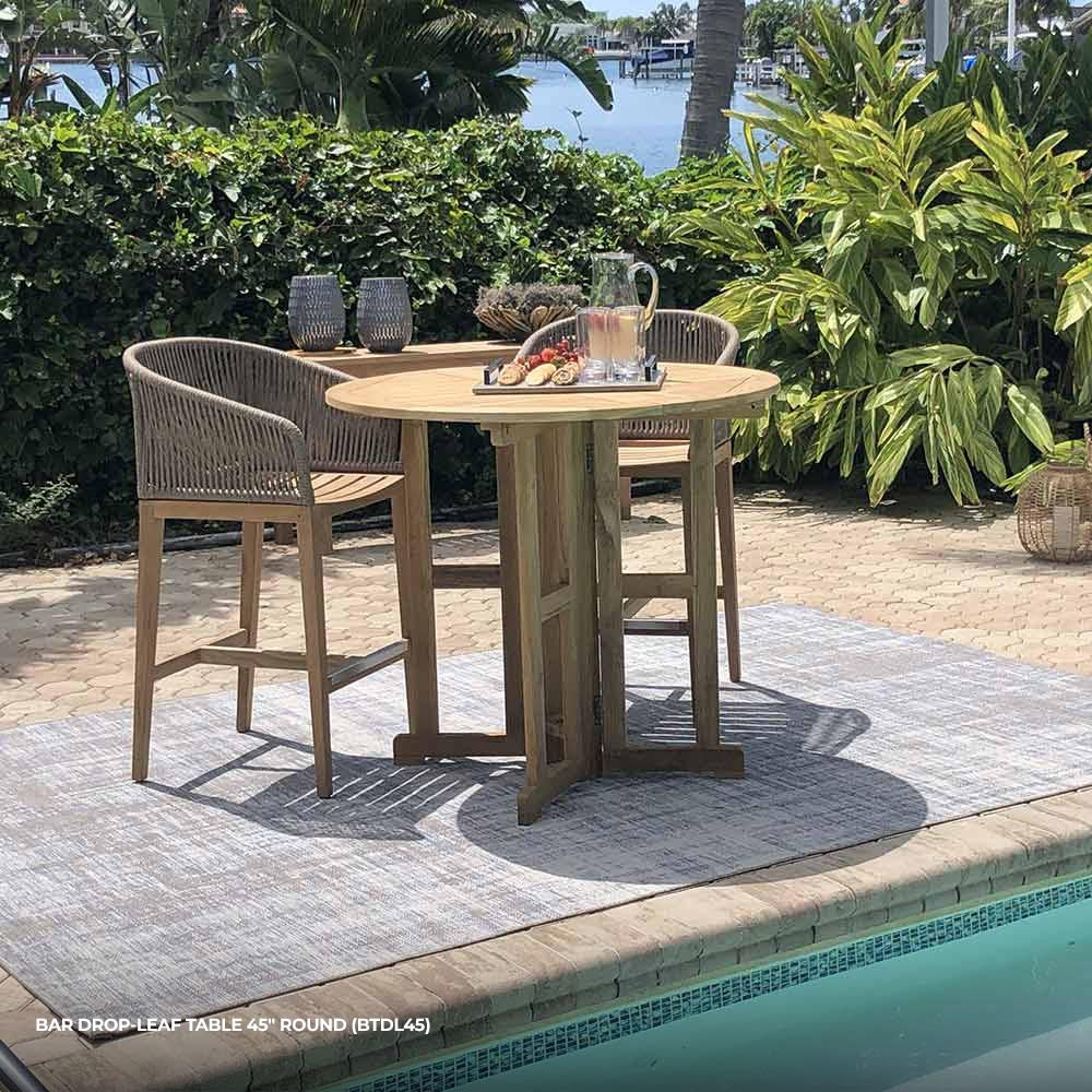 Round drop-leaf teak bar table with central pedestal base and slatted top