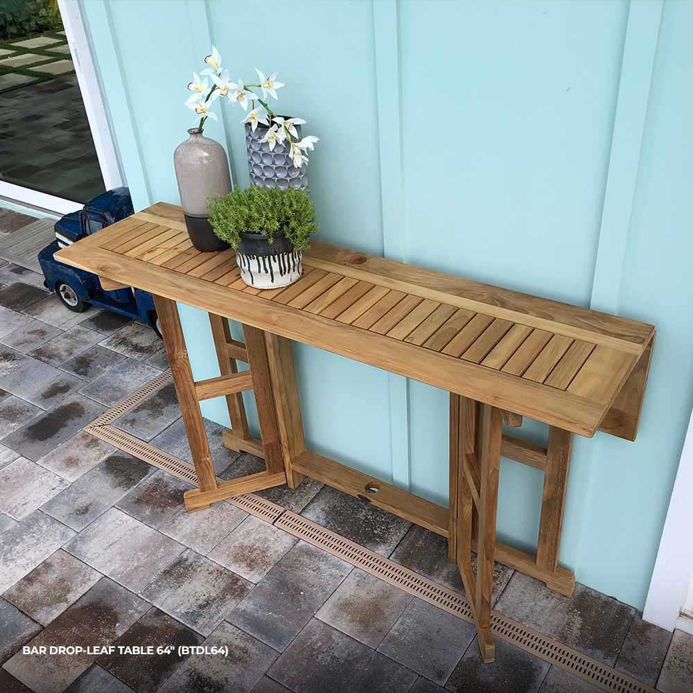Rectangular teak drop-leaf bar table with slatted top against a wall
