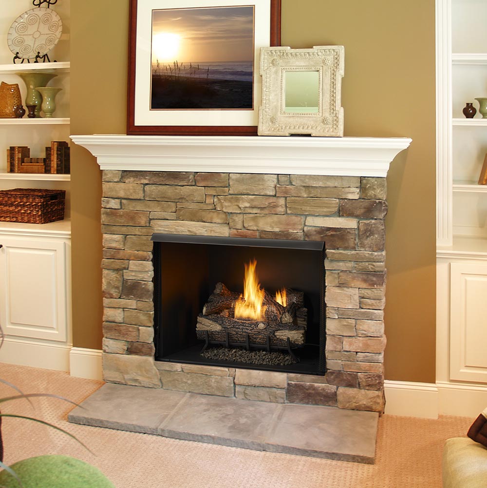 Vent-free fireplace insert with burning gas logs set into a stone fireplace surround