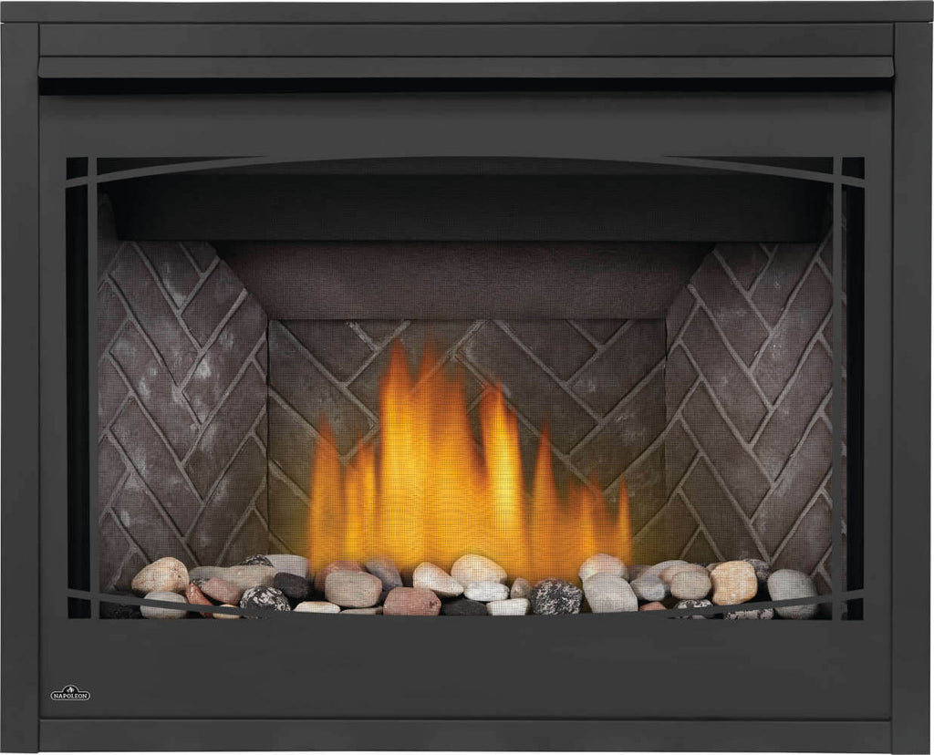 Direct vent gas fireplace insert with black trim, glass front, and flame over light rocks