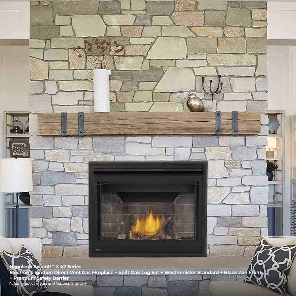 Direct vent gas fireplace insert with black frame and burning logs set in a stone surround
