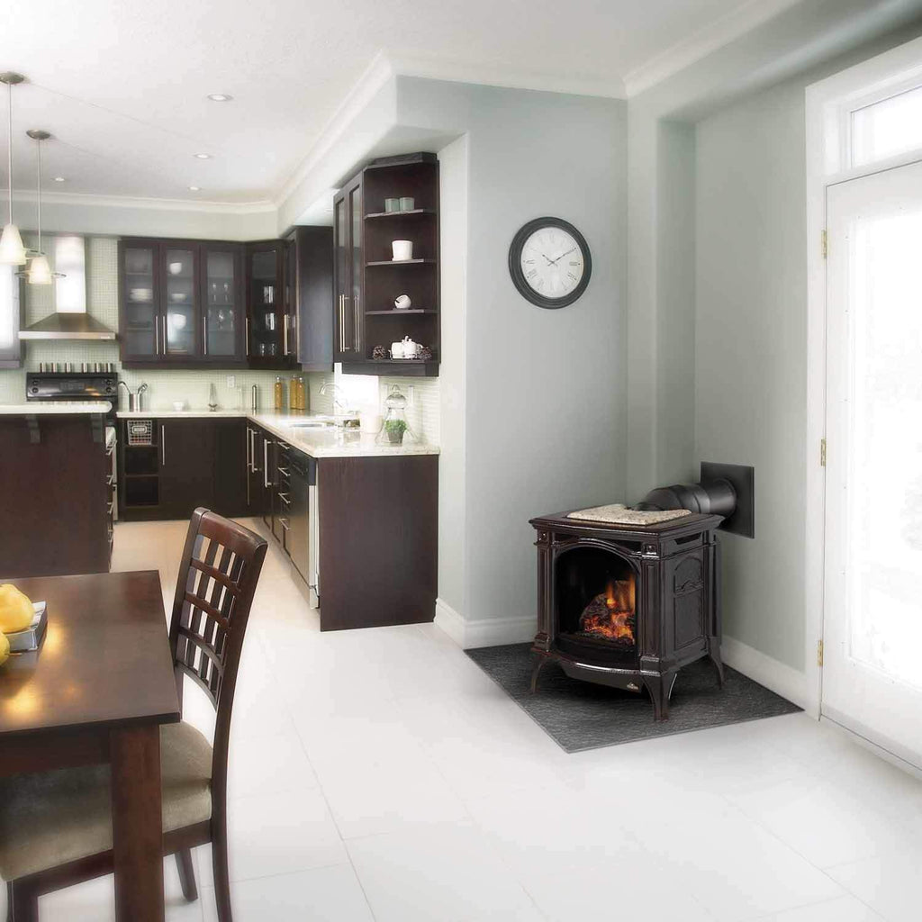Freestanding cast iron gas stove with arched glass door and burning logs
