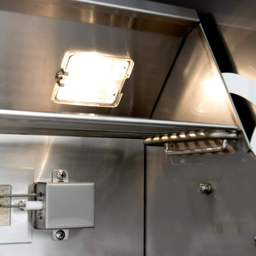 Gas grill interior with built-in work light and rear cooking hood panel