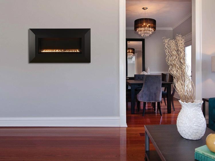 Linear ventless fireplace insert in black surround with burning flames behind front glass