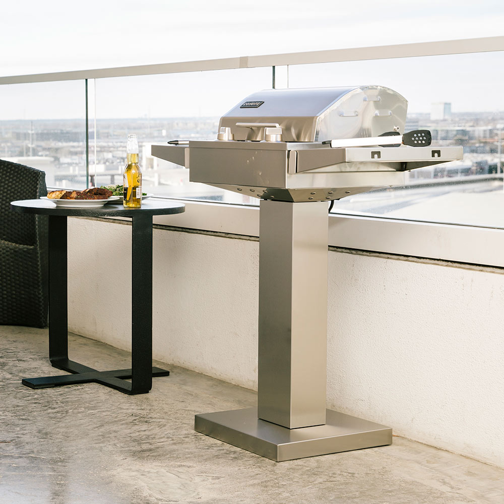 Stainless steel electric grill pedestal with lid closed on rooftop patio