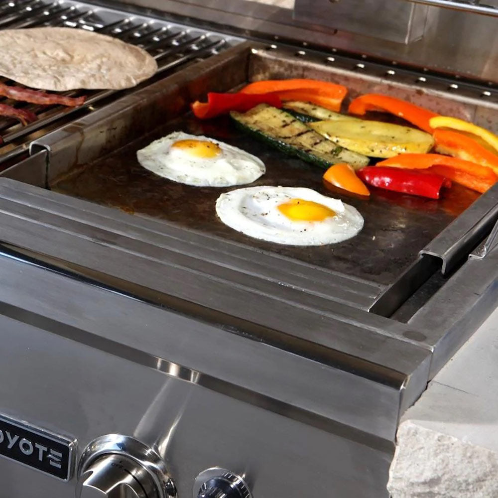 Stainless steel griddle insert cooking with eggs and sliced peppers on flat surface