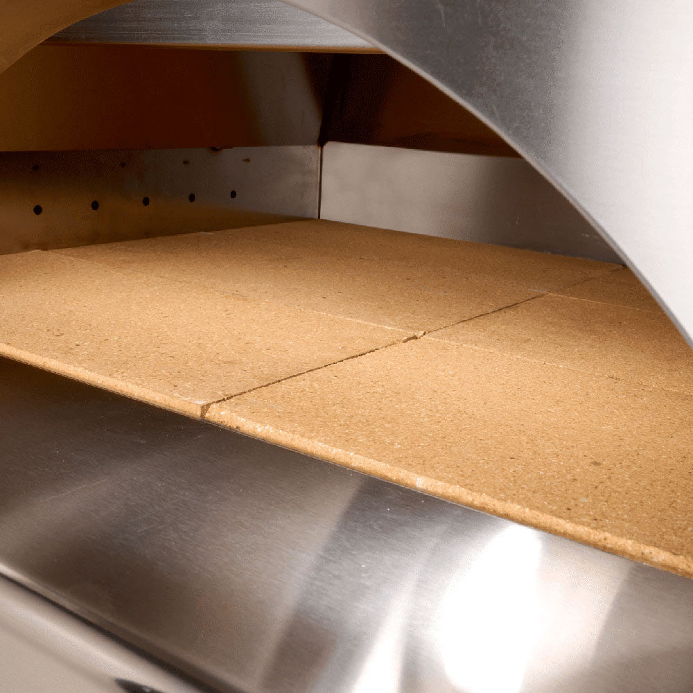 Pizza oven cooking chamber with tan stone baking surface and stainless side walls