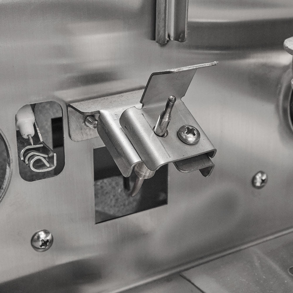 Stainless steel gas grill ignition area with electrode and burner control assembly