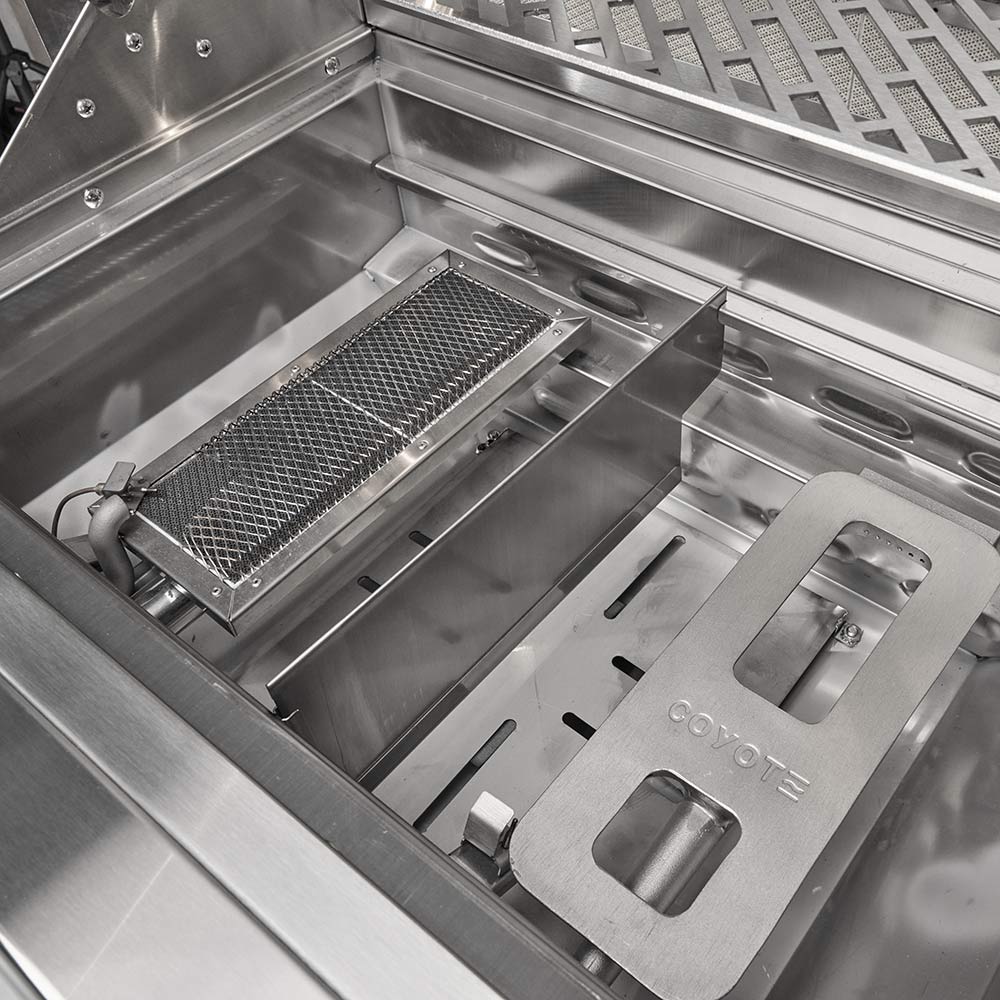 Built-in gas grill interior with cooking grates, burners, and metal heat shield