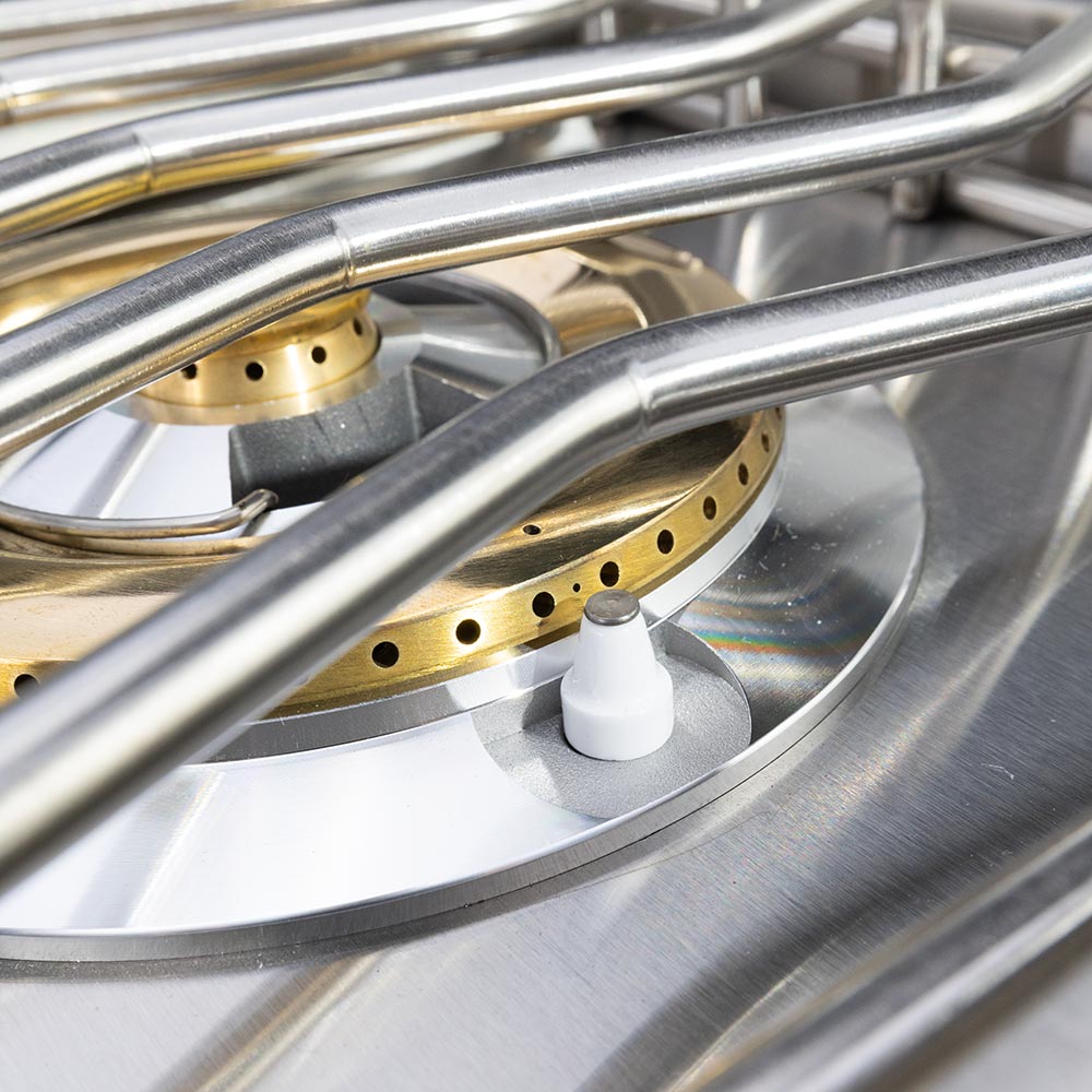 Stainless side burner with brass burner head and ignition knob, close-up