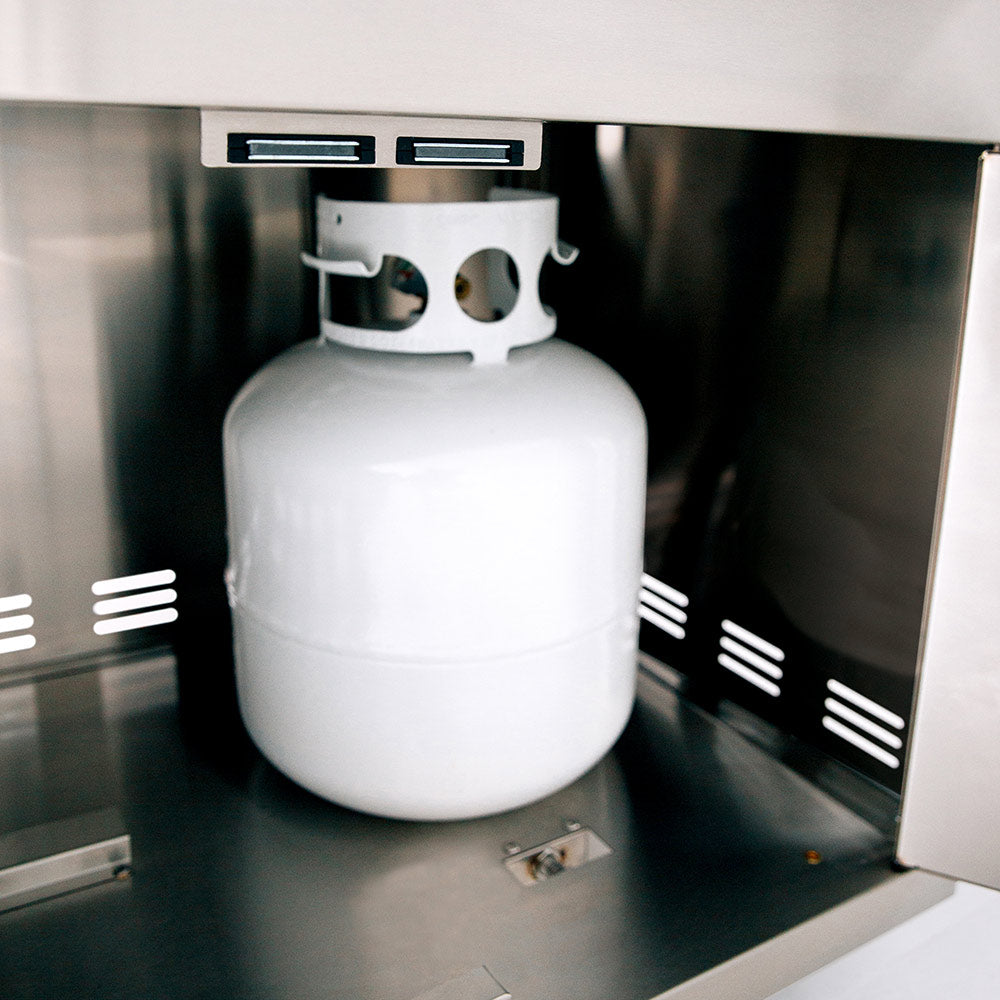 White propane tank in storage compartment of stainless steel grill cart