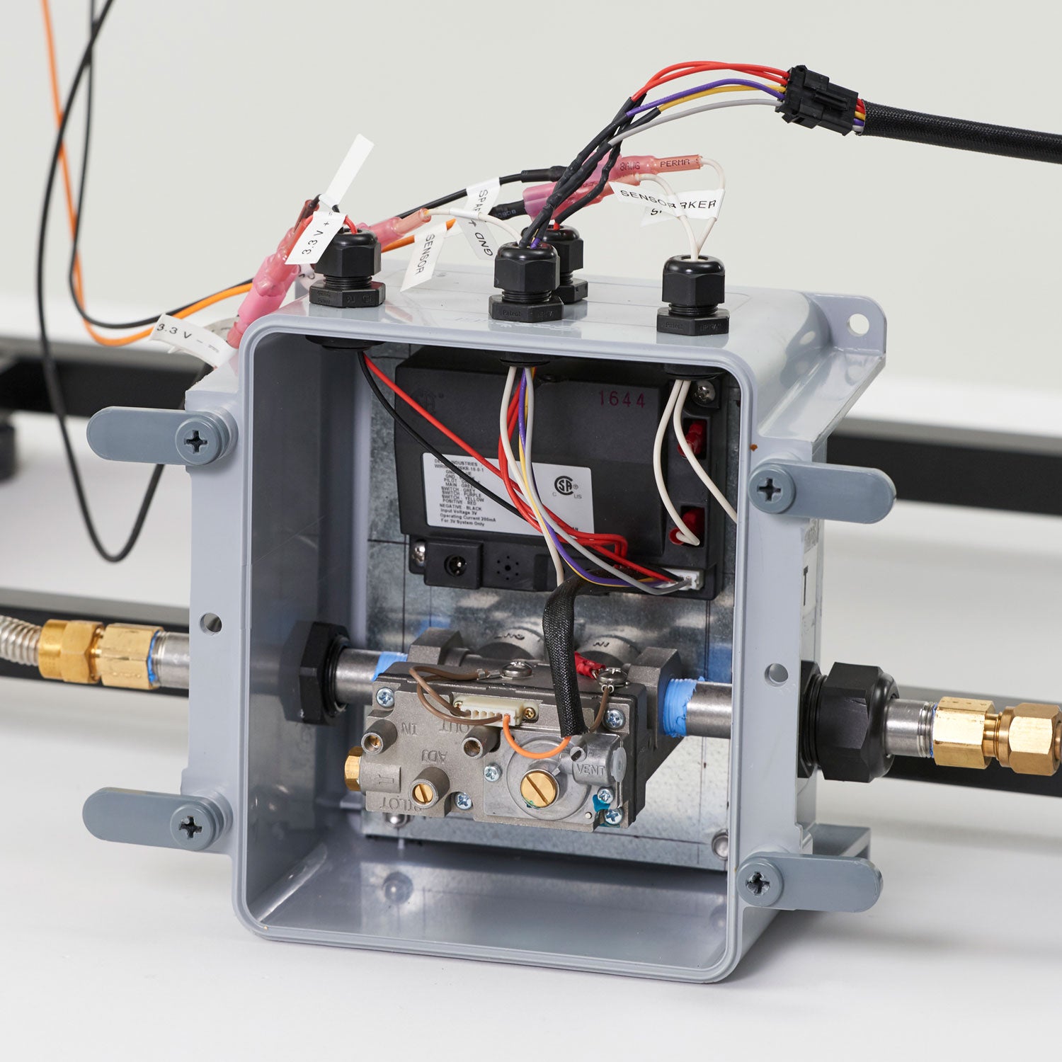 Gas fire pit ignition control box with open cover and internal components