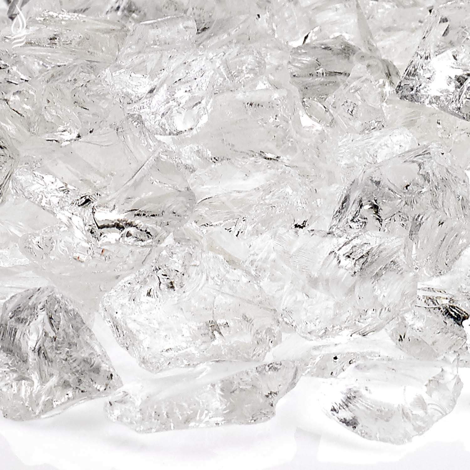 Close-up of clear ice-toned recycled fire glass chunks with reflective facets.