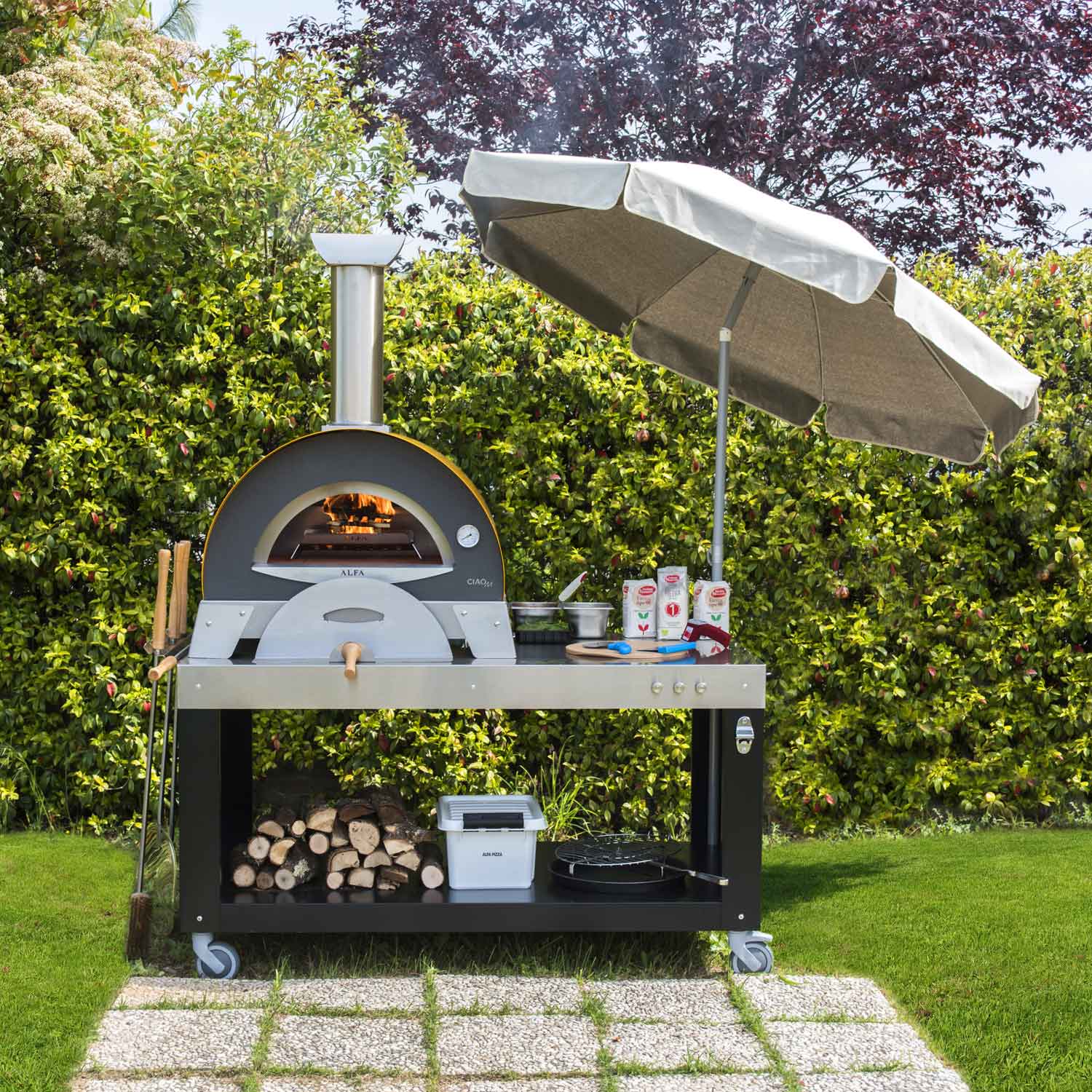 Outdoor wood-fired pizza oven with black dome, side shelf, and covered chimney