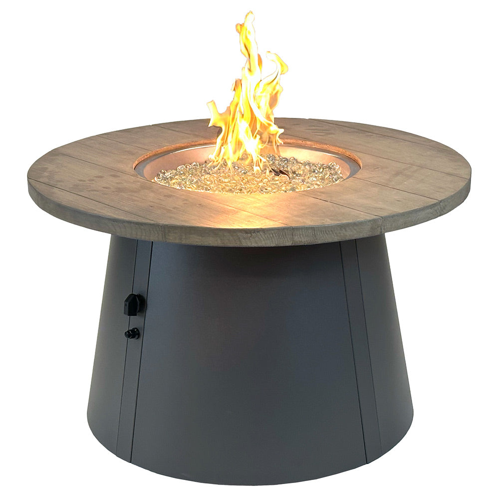 Round gas fire pit table with wood-look top and black base, burning flame in center