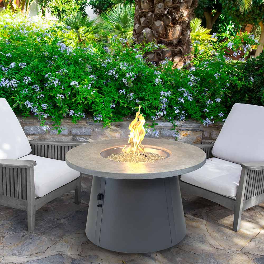 Round gas fire pit table with burning flame in circular burner