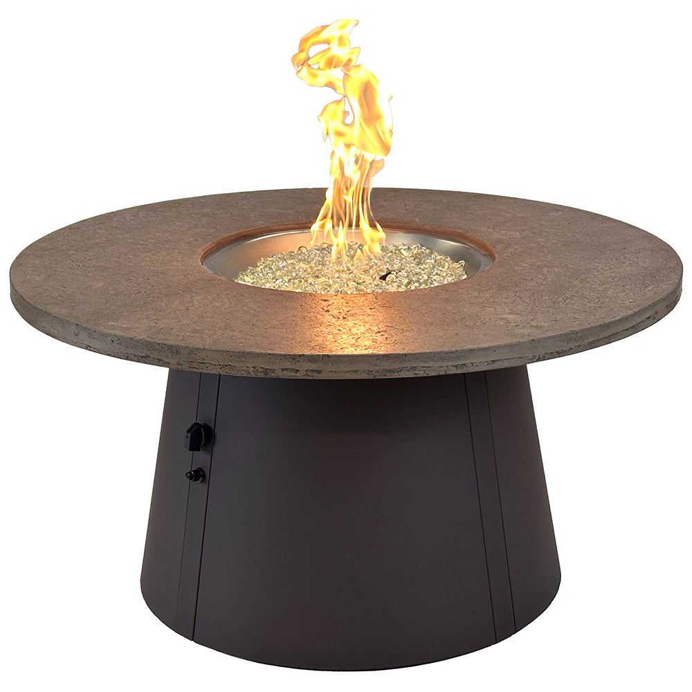 Round gas fire pit table with brown stone top and flame centered in burner