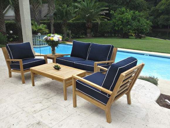 Teak patio seating set with two chairs and navy cushions, plus a matching coffee table