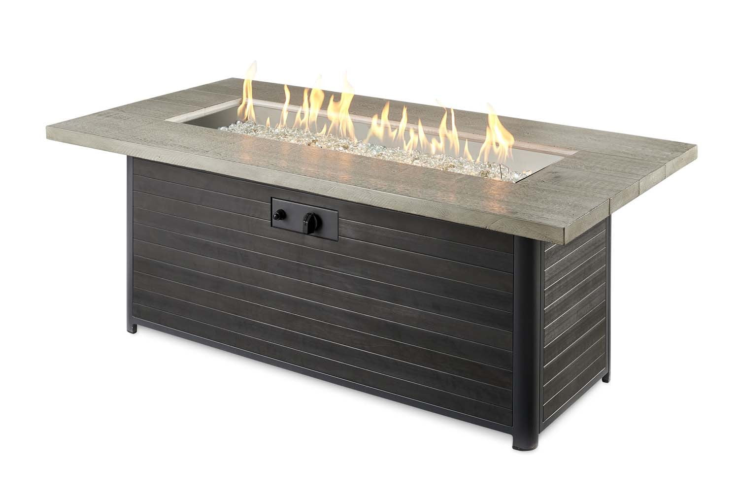 Rectangular gas fire pit table with dark cabinet and stone-look top, open flame
