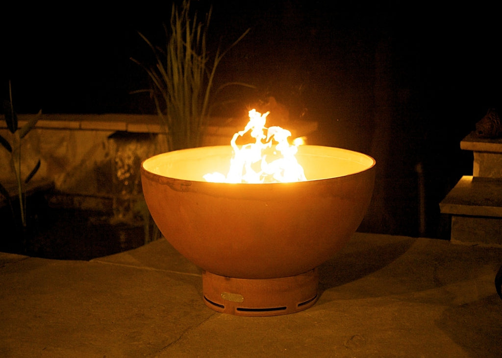 Crater gas fire pit with burning flames in a round bowl and vented base.