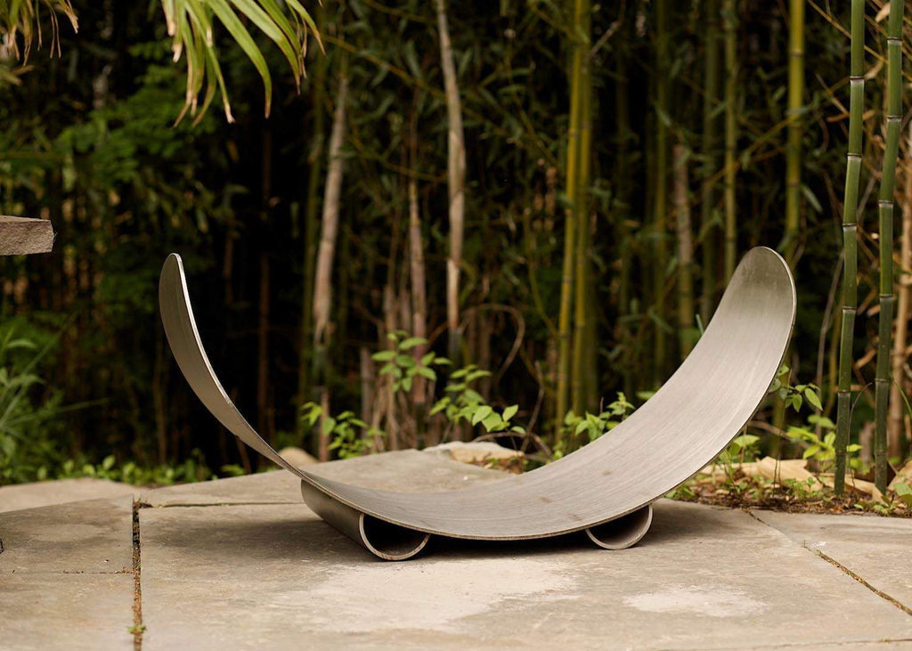 Stainless steel crescent firewood log rack resting on curved runners
