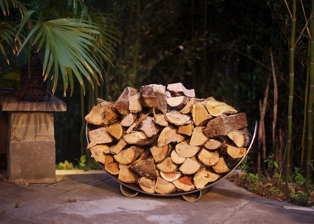 Crescent stainless steel log rack filled with stacked firewood logs