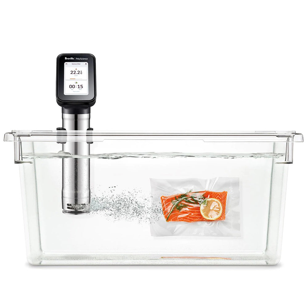 Sous vide immersion circulator mounted in clear rectangular water bath with bag of food
