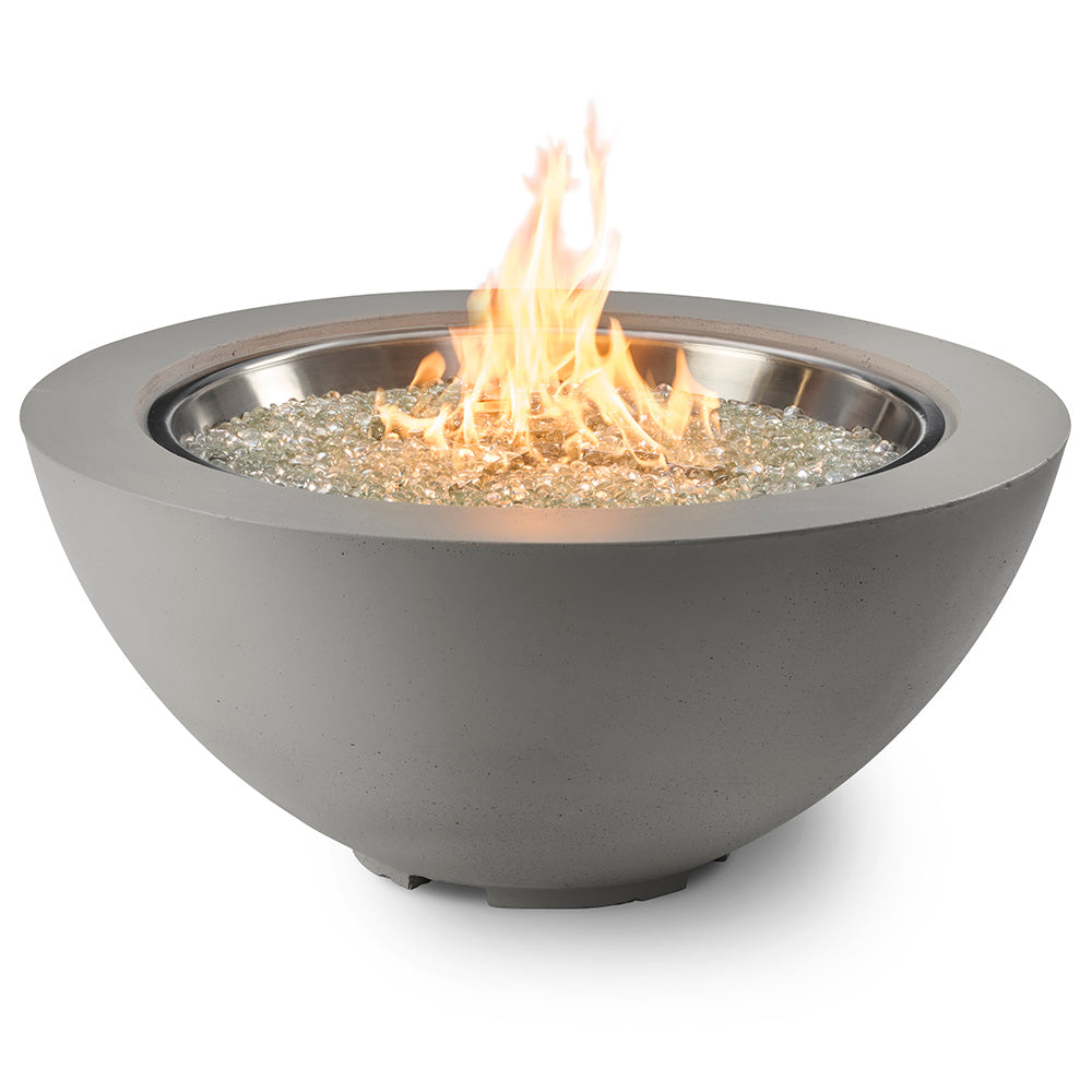 Grey gas fire pit bowl close-up with flames and glass burner media