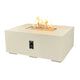 Outdoor linear gas fire pit table in white with burning flames in the top glass tray