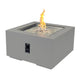 Square gas fire pit table in medium gray with flames over decorative gravel, side control panel.