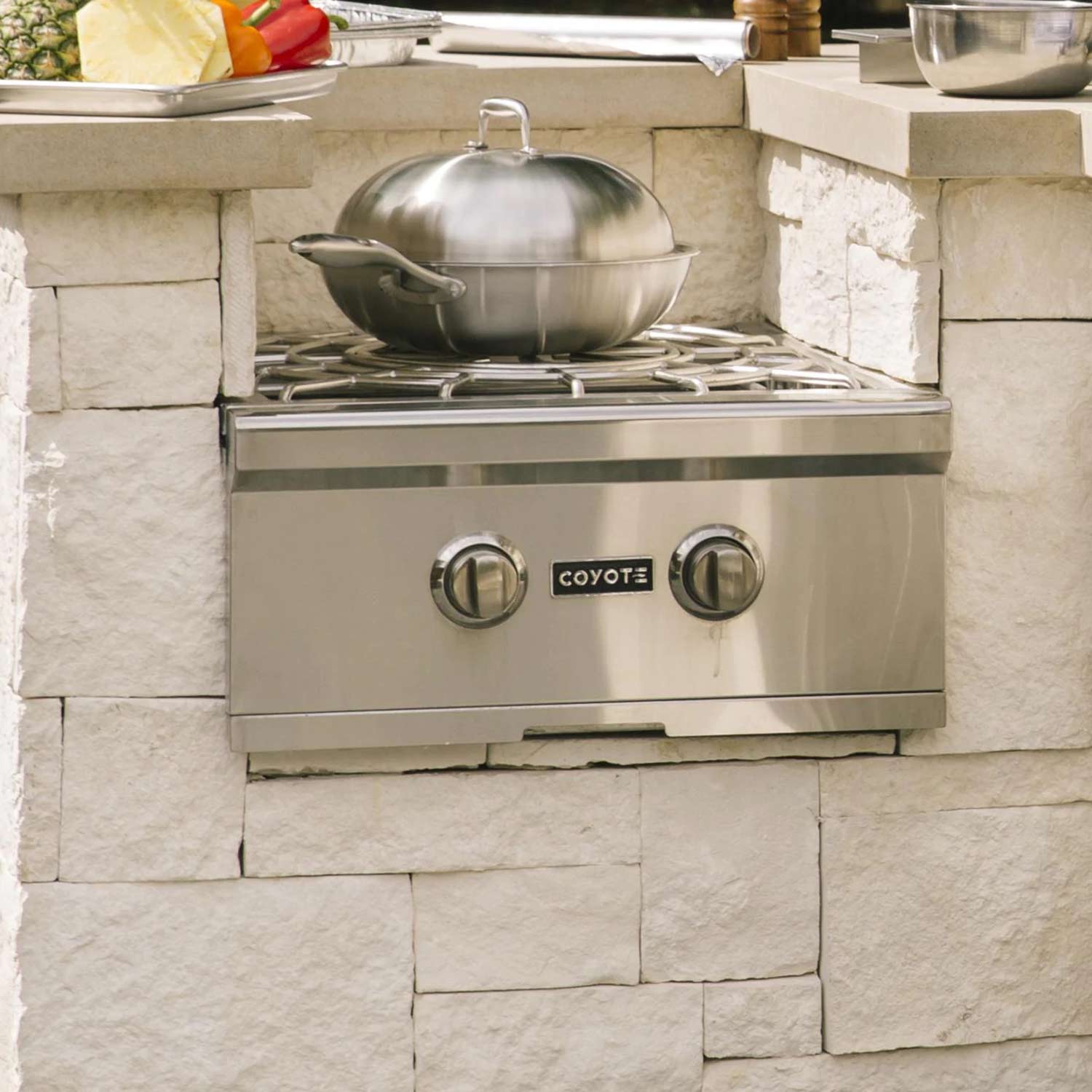 Stainless steel wok with domed lid and side handles on gas burner grate