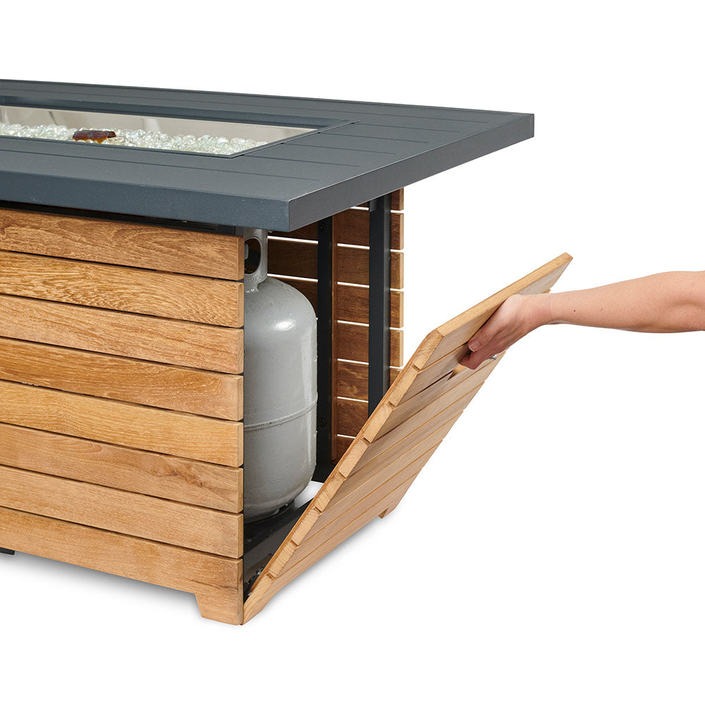 Gas fire pit table with teak base and dark aluminum lid; side compartment detail