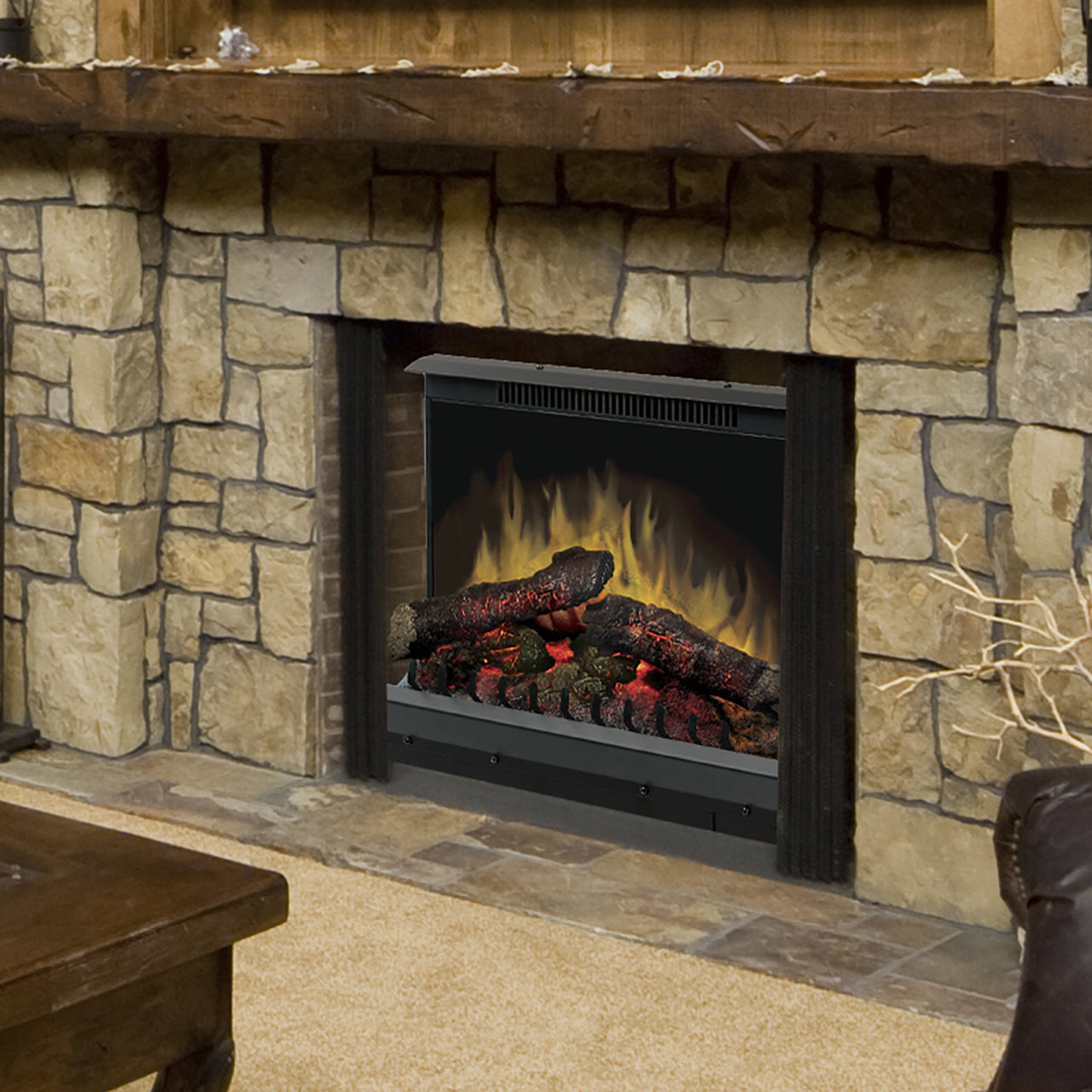 Electric fireplace insert installed in stone surround, black frame with burning logs