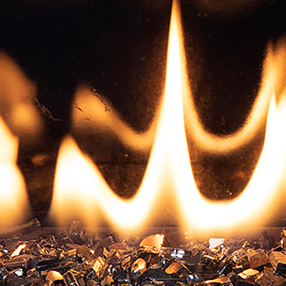 Crushed glass fire bed with bright flames burning inside a gas fireplace