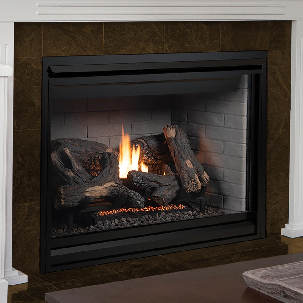 Black direct vent gas fireplace set into a stone surround, burning logs