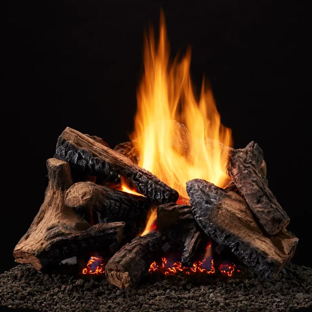 Vented gas log set with dark logs and bright orange flames over black gravel base
