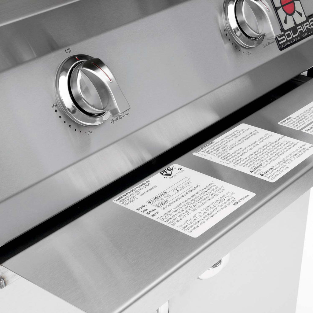 Stainless steel control panel with two knobs and warning label