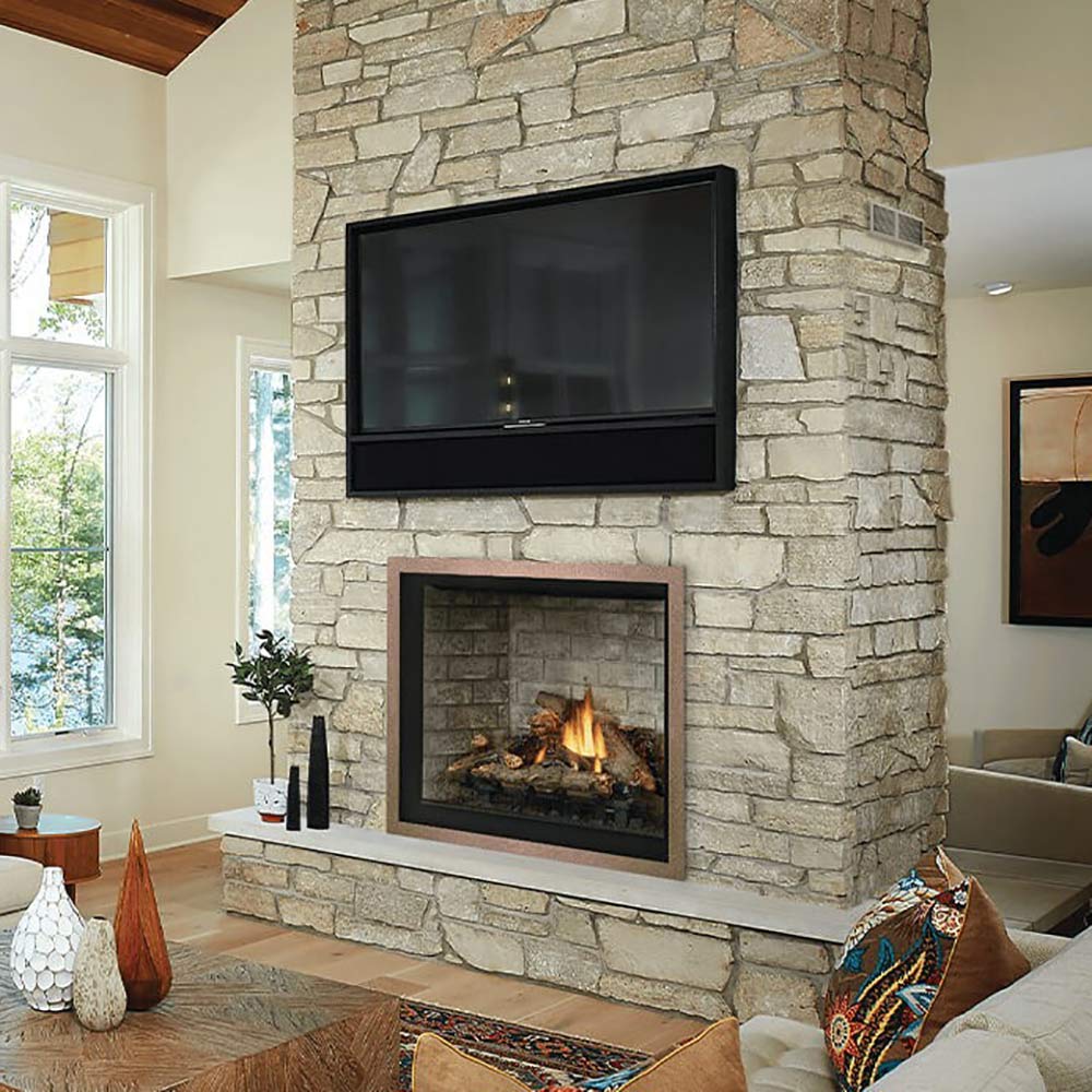 Direct vent gas fireplace with black firebox set into stone wall, flames burning