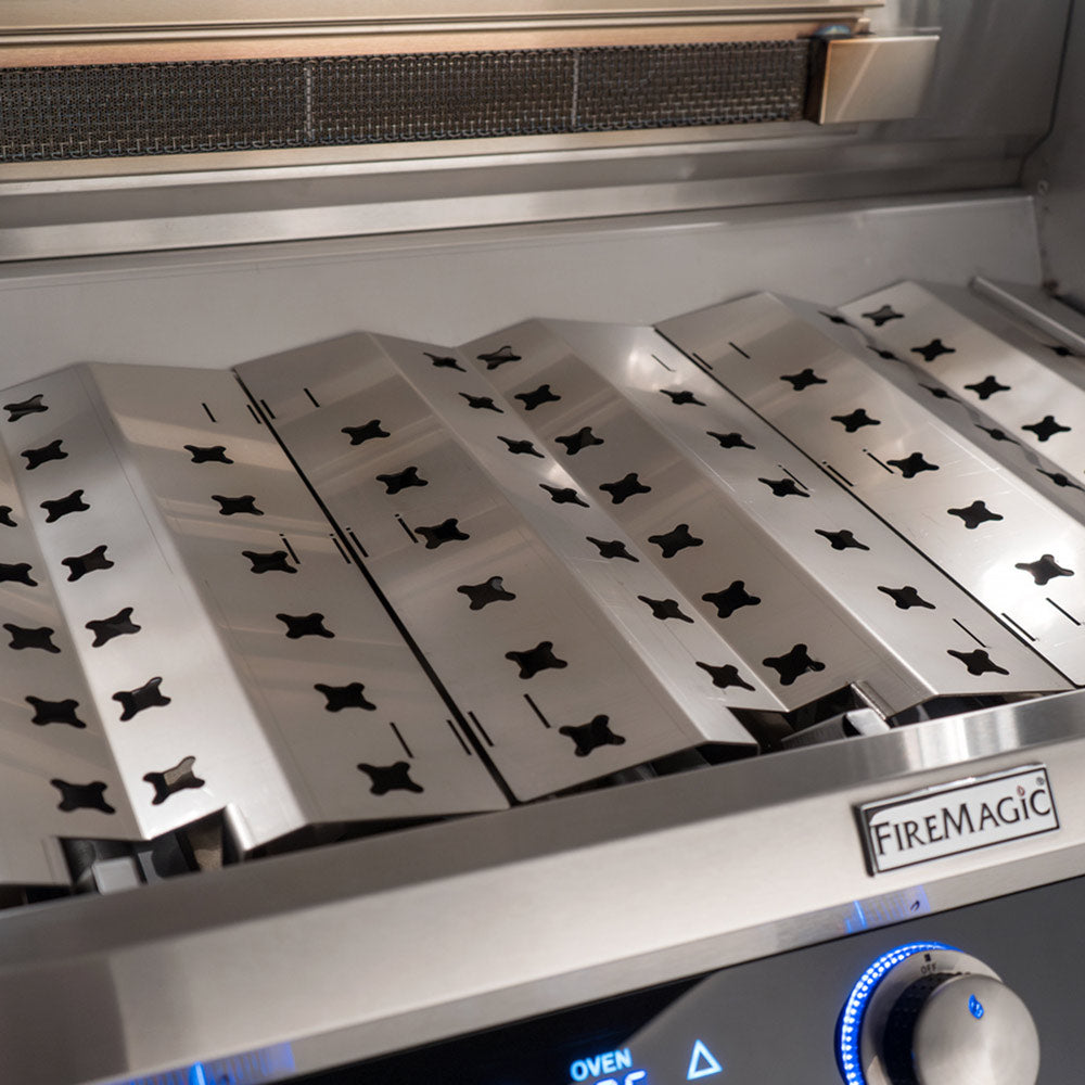 Stainless steel grill burner area with “FIREMAGIC” label