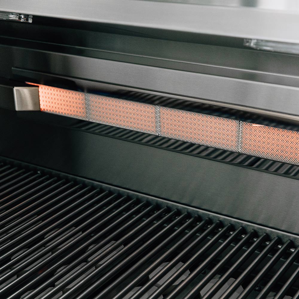 Glowing infrared ceramic heat strip between stainless grill grates