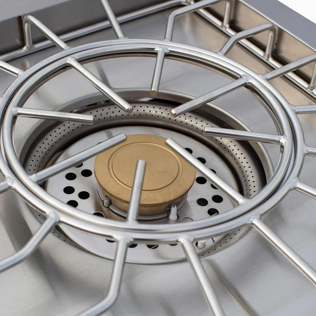 Stainless steel burner with circular flame cap and grate close-up