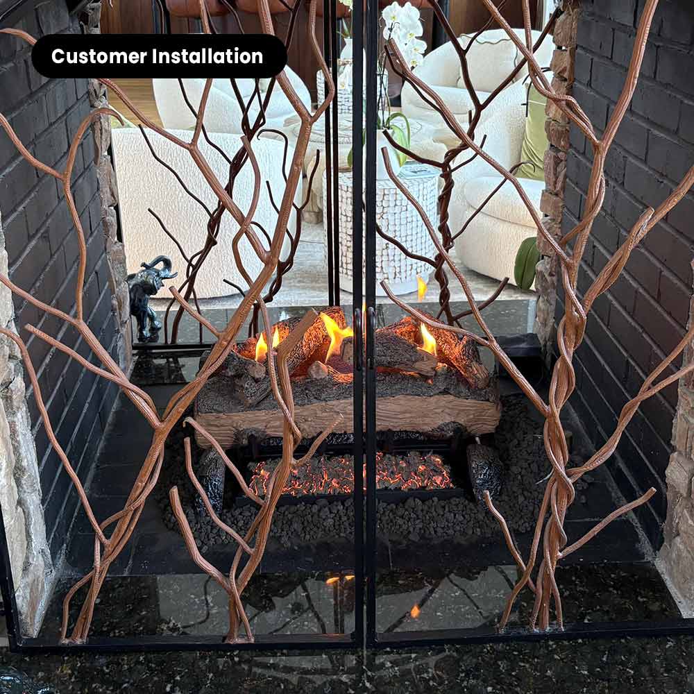 See-through ventless gas firepit with burning split logs behind glass screen